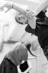 Dancer with focused expression in studio rehearsal, black and white