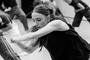Contemporary dancer in motion during rehearsal in studio, black and white