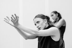 Dancer with focused expression in studio rehearsal, black and white