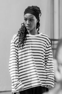 Dancer with focused expression in studio rehearsal, black and white