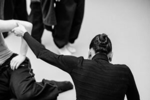 Close-up of dancers’ hands interacting during rehearsal, black and white