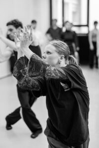 Dancer with focused expression in studio rehearsal, black and white