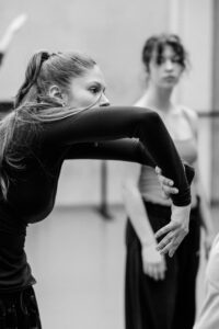 Contemporary dancer in motion during rehearsal in studio, black and white