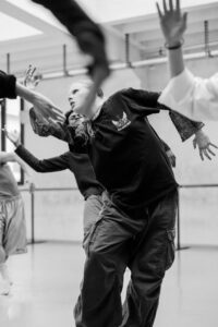 Contemporary dancer in motion during rehearsal in studio, black and white