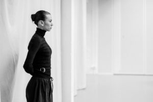 Dancer with focused expression in studio rehearsal, black and white