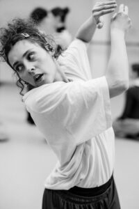 Dancer with focused expression in studio rehearsal, black and white
