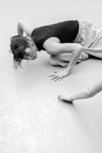 Contemporary dancer in motion during rehearsal in studio, black and white