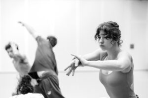 Dancer with focused expression in studio rehearsal, black and white