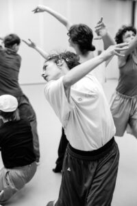 Contemporary dancer in motion during rehearsal in studio, black and white