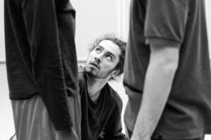 Dancer with focused expression in studio rehearsal, black and white