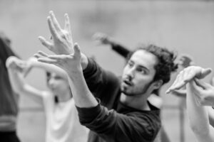 Close-up of dancers’ hands interacting during rehearsal, black and white
