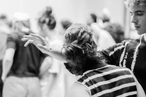 Close-up of dancers’ hands interacting during rehearsal, black and white