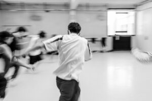 Contemporary dancer in motion during rehearsal in studio, black and white