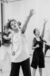 Contemporary dancer in motion during rehearsal in studio, black and white