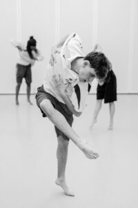 Contemporary dancer in motion during rehearsal in studio, black and white