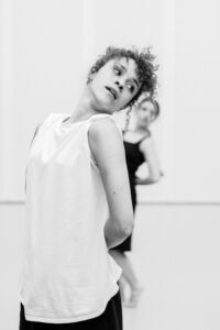 Dancer with focused expression in studio rehearsal, black and white