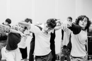 Dancer with focused expression in studio rehearsal, black and white