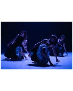 Four dancers kneel in sculptural poses under deep blue light during Land of Hope by Cie Linga.